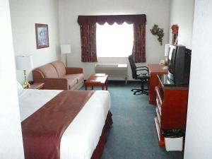 a hotel room with a bed and a television at Coast Abbotsford Hotel & Suites in Abbotsford