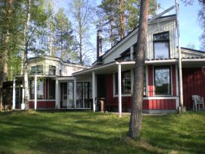 a red house with a tree in the yard at Lomakoivulehto in Saarijärvi
