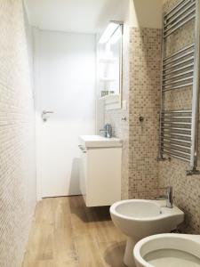 ein weißes Bad mit einem Waschbecken und einem WC in der Unterkunft Miramare Apartment Genova in Genua