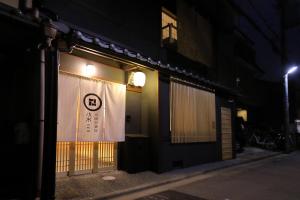un negozio con una tenda bianca nella vetrina di notte di 京一軒町家 染 SEN 七条壬生 Shichijo-Mibu a Kyoto
