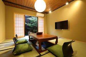sala de estar con mesa, sillas y TV en 染 SEN 七条壬生 Shichijo-Mibu, en Kioto