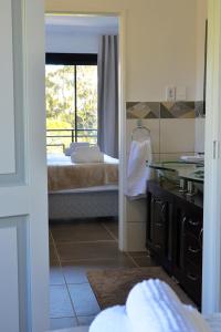 a bathroom with a view of a bedroom with a balcony at Villa Honeysuckle Luxury 4 Bedroom in Stellenbosch