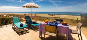 Una mesa y sillas en un balcón con vista a la playa. en Apartamentos Voramar, en Castelldefels