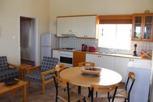 a kitchen with a table and a table and chairs at Zenovia Garden House in Pissouri