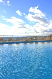 a row of benches sitting next to a body of water at Paradise Beach in Porto Santo