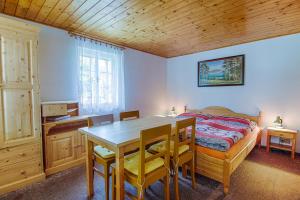 1 dormitorio con 1 cama, mesa y sillas en Chalupa Zuzánek 50 en Rokytnice nad Jizerou