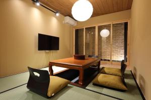 a living room with a table and a chair at 京一軒町家 染 SEN 七条花畑 Shichijo-Hanabatake in Kyoto