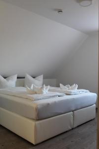 Una cama blanca con dos almohadas blancas. en Gästehaus Hubertushof - 24h Check-In, en Hausen