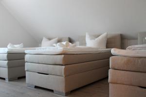 2 camas y un sofá en una habitación en Gästehaus Hubertushof - 24h Check-In, en Hausen