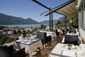 um restaurante com mesas e cadeiras numa varanda com vista em B&B Toblerina em Ascona