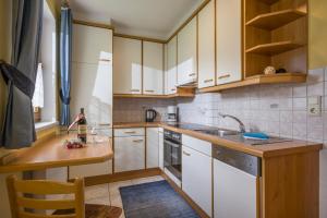 a kitchen with white cabinets and a sink at Ferienwohnungen Familie Rieder in Kaltenbach +11 photos