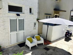 algumas cadeiras, um guarda-chuva e uma scooter em Ayre Apartman Split em Split