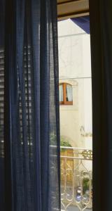 ein Fenster mit blauen Vorhängen und einem Balkon in der Unterkunft Acqua di Mare B&B in San Vito lo Capo