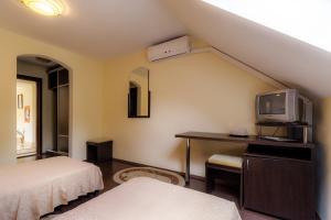 カリマネシュティにあるPensiunea Alfridのベッド、テレビ、デスクが備わる客室です。