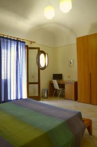 Schlafzimmer mit einem Bett und einem Schreibtisch mit einem Computer in der Unterkunft Acqua di Mare B&B in San Vito lo Capo