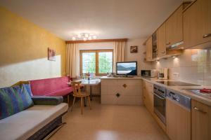 a kitchen with a couch and a table in a room at Ferienwohnungen Familie Rieder in Kaltenbach