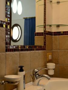 ein Bad mit einem Waschbecken und einem Spiegel in der Unterkunft Acqua di Mare B&B in San Vito lo Capo