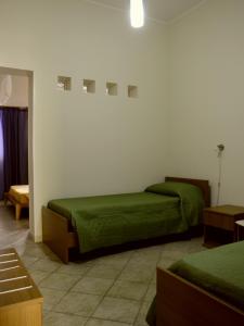サン・ヴィート・ロ・カーポにあるAcqua di Mare B&Bのベッド2台(緑のシーツ付)が備わる客室です。