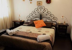 a bed with an orange pillow and towels on it at Villa Gandamar in Santa Teresa Gallura