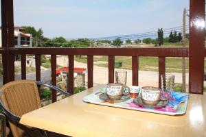 a table with three coffee cups on a balcony at Maria Studios in Neo Klima