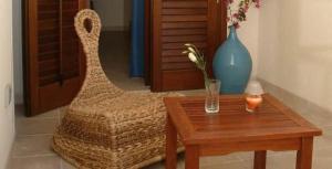 Zimmer mit einem Tisch, einem Stuhl und einer Vase in der Unterkunft Acqua di Mare B&B in San Vito lo Capo