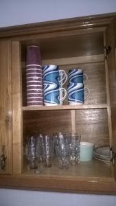 un armario de madera con vasos y platos. en Casa de Campo São Bernardo, en Penalva do Castelo