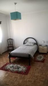 - une chambre avec un lit, une chaise et un tapis dans l'établissement Casa de Campo São Bernardo, à Penalva do Castelo