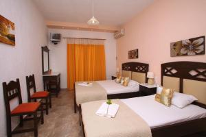 a hotel room with two beds and a table and chairs at Maria Studios in Neo Klima