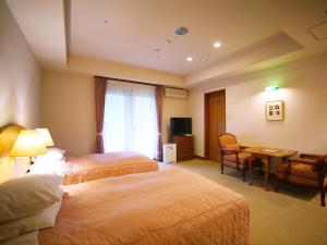 a hotel room with two beds and a desk at Chuzenji Kanaya Hotel in Nikko