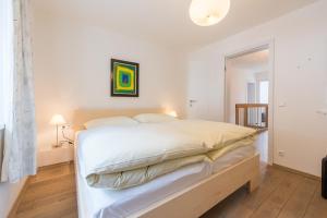 ein weißes Schlafzimmer mit einem großen Bett mit weißer Bettwäsche in der Unterkunft Haus Kissel in Saalbach-Hinterglemm