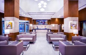 a waiting room with brown chairs and a bar at Golden Tulip Le Diplomate in Cotonou