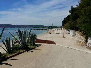 a beach with people swimming in the water at Apartment Pletikosic in Kaštela