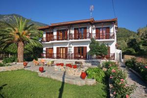 a large white building with a palm tree in front of it at Maria Studios in Neo Klima