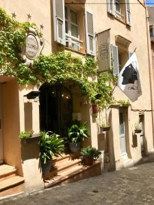 un bâtiment avec des plantes en pot devant lui dans l'établissement COLOMBA Hôtel Restaurant, à Bonifacio