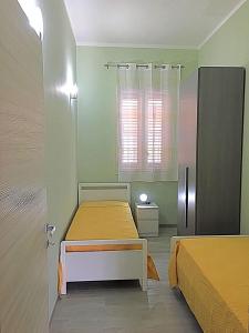アヴォラにあるCasa Giuliのベッド2台、冷蔵庫が備わる小さな客室です。