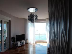 uma sala de estar com uma televisão e um lustre em Apartment Splendid em Split
