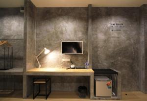 a room with a desk with a computer on a wall at THAI THANI Loft & Life Lamphun in Lamphun