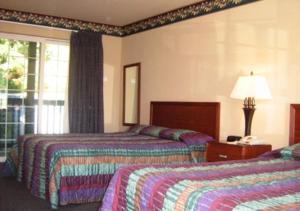 Habitación de hotel con 2 camas y ventana en Westhaven Inn en Pollock Pines