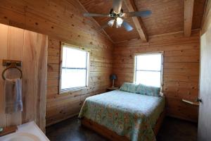 - une chambre avec un lit dans une cabane en bois dans l'établissement River Bluff Cabins, à Rio Frio