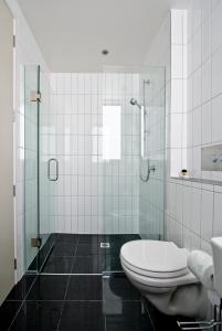 a bathroom with a toilet and a glass shower at Ohope Beach Resort in Ohope Beach