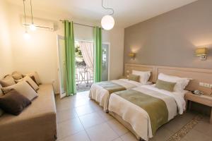 two beds in a bedroom with green curtains at Ikion Eco Boutique Hotel in Patitiri