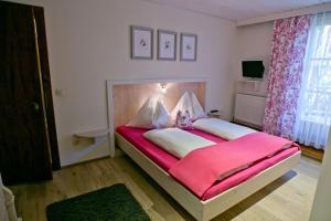 a bedroom with a large bed with a pink blanket at Appartement Ferienhof Ortnergut in Eben im Pongau