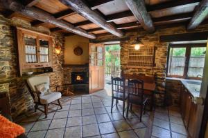 a living room with a fireplace and a table and chairs at Casas da Lexa in Taramundi