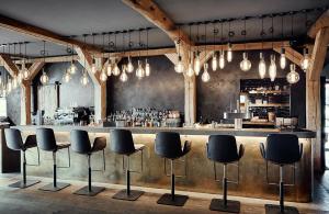 a bar with black stools in front of a counter at Landhaus Flottbek Boutique Hotel in Hamburg