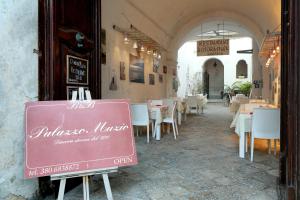 a restaurant with a sign in front of a tables and chairs at B&B Dimora Muzio and Restaurant in Gallipoli