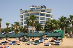 a hotel on the beach with chairs and palm trees at Venessa Beach Hotel in Avsallar