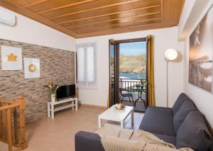 a living room with a couch and a tv at Castello Di Porto in Panormos Rethymno