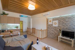 a living room with a couch and a tv and a kitchen at Castello Di Porto in Panormos Rethymno