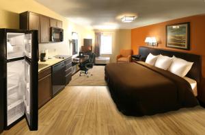 a hotel room with a large bed and a desk at Suburban Studios Washington, PA in Washington