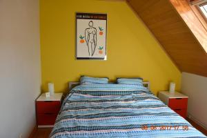 - une chambre dotée d'un lit avec un mur jaune dans l'établissement Damon II, à Poelkapelle